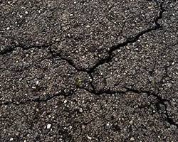 Why do asphalt cracks form?