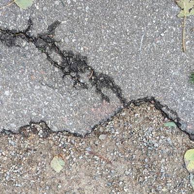 There are thin cracks on the surface of the asphalt.